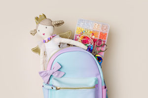 Fashion backpack with ragdoll, beads and boxes for children's needlework and crafts. Kids stuff and accessory for creativity and hobby.