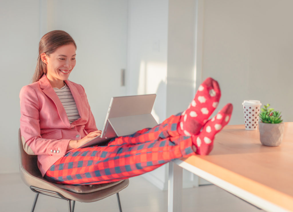 woman working in pajamas with feet on desk