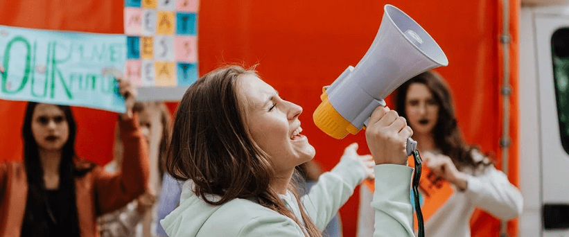 woman speaking into megaphone to a crowd