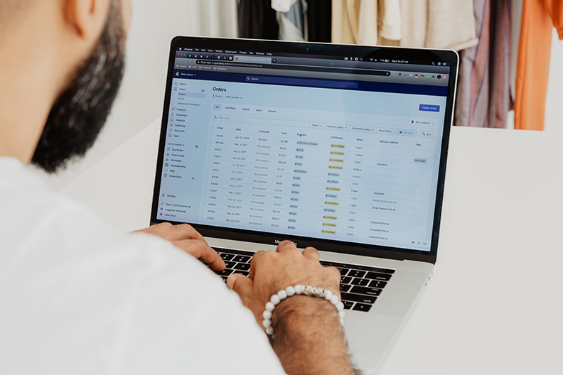 Man looking at laptop with spreadsheet on screen