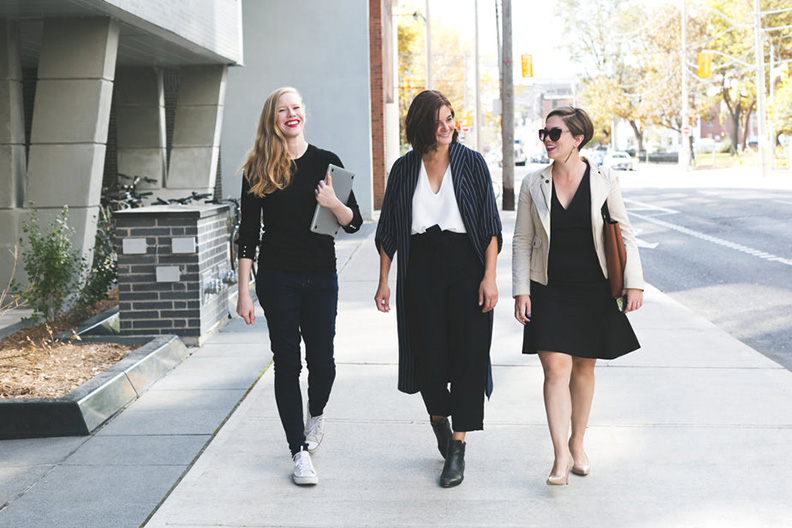 Three women walking down the street smiling
