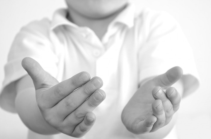 young boy with hands out