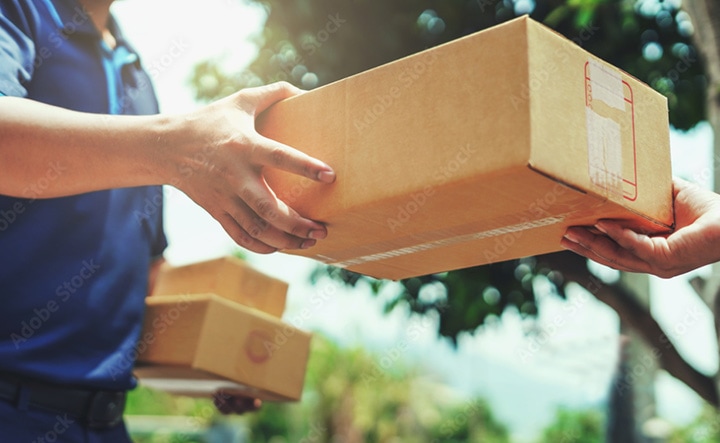 man with packages hands a package to other man