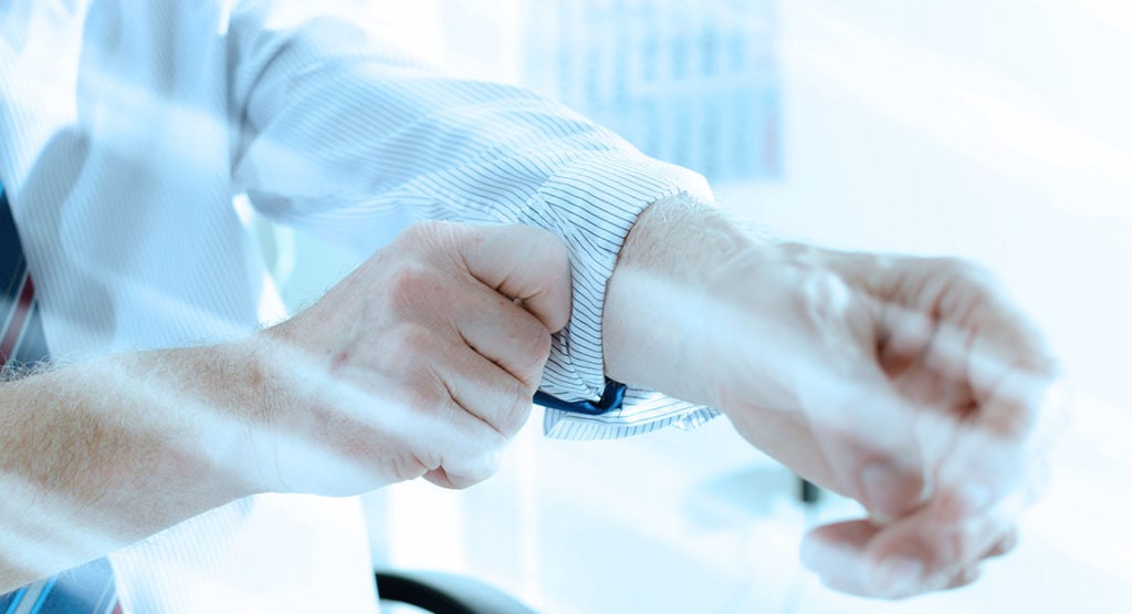 Businessman rolling up his sleeve at office; light effect