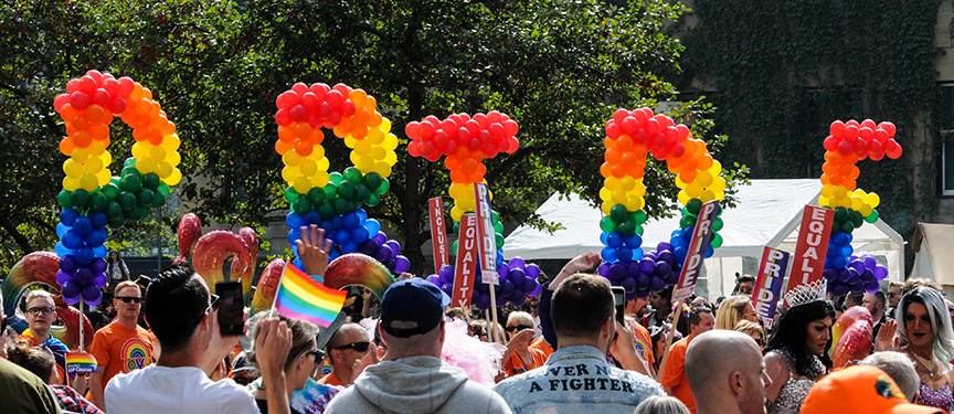 Festival goers holding up letters that read PRIDE