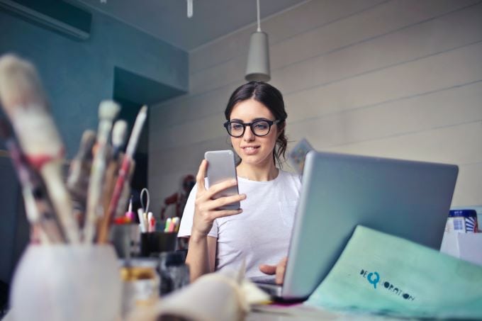 woman with phone and laptop: credit Bruce Mars Unsplash