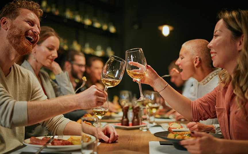 group of friends dining for a fundraiser toasting with wine glasses