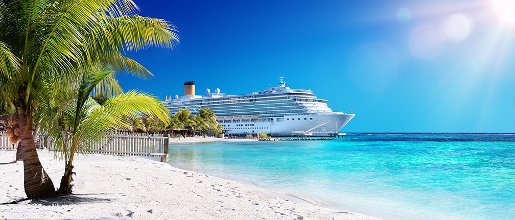 beautiful crusie ship off shore of sandy beaches with palm trees and crystal clear water