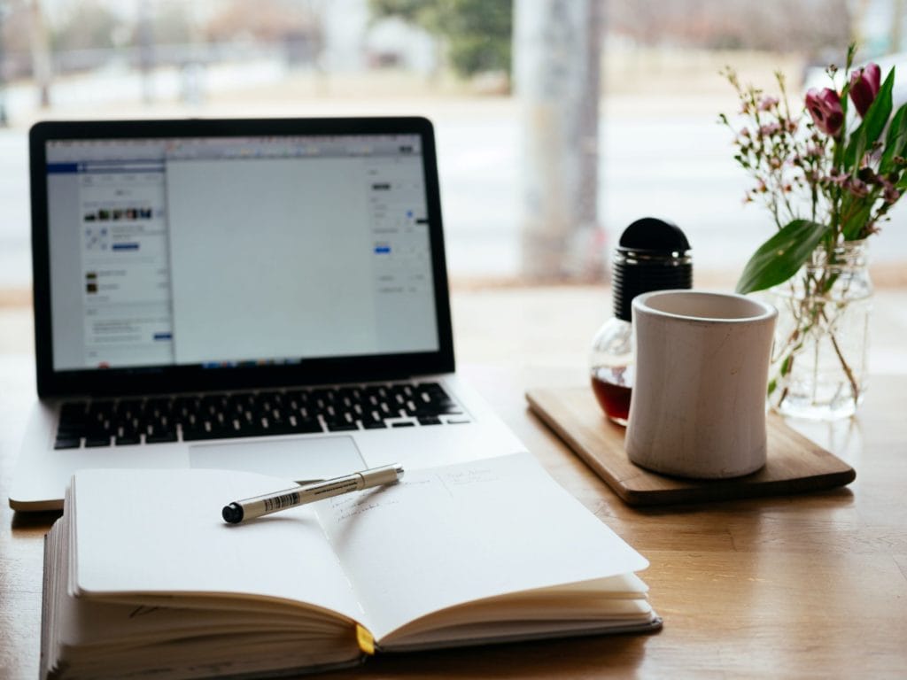 laptop with notebook and coffee cup