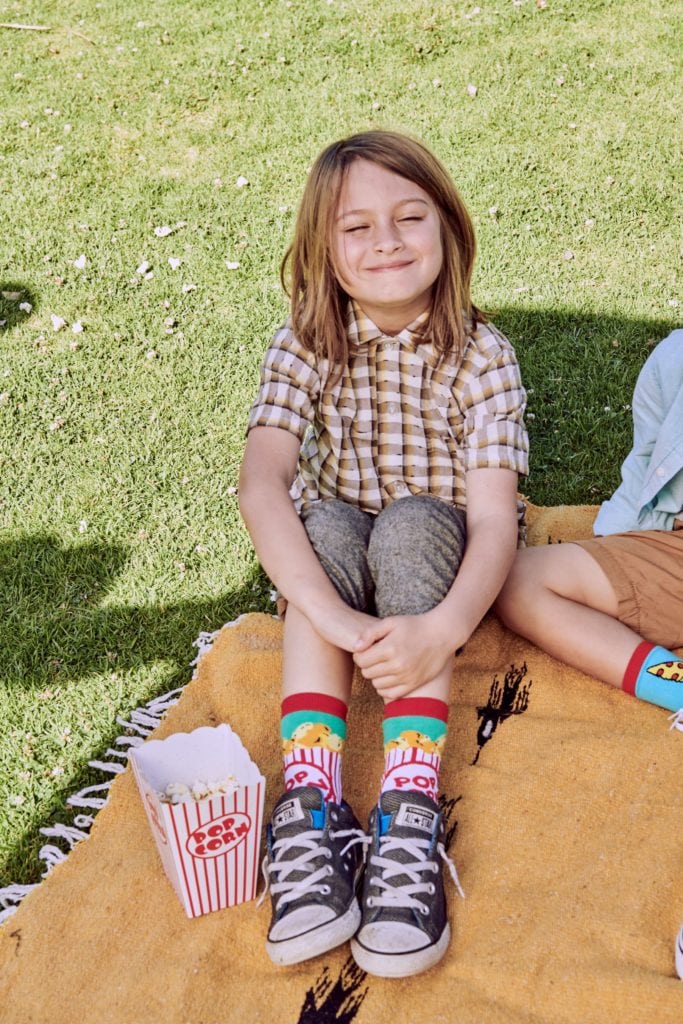 kids on blanket on lawn with popcorn