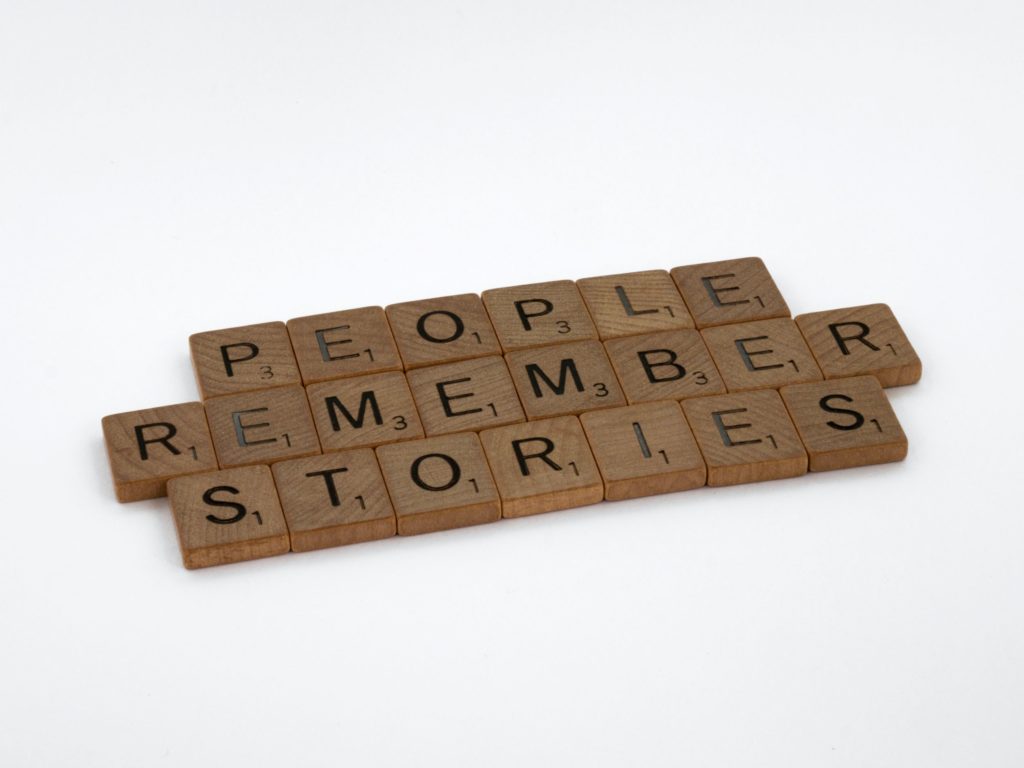 scrabble tiles that spell out "people remember stories"