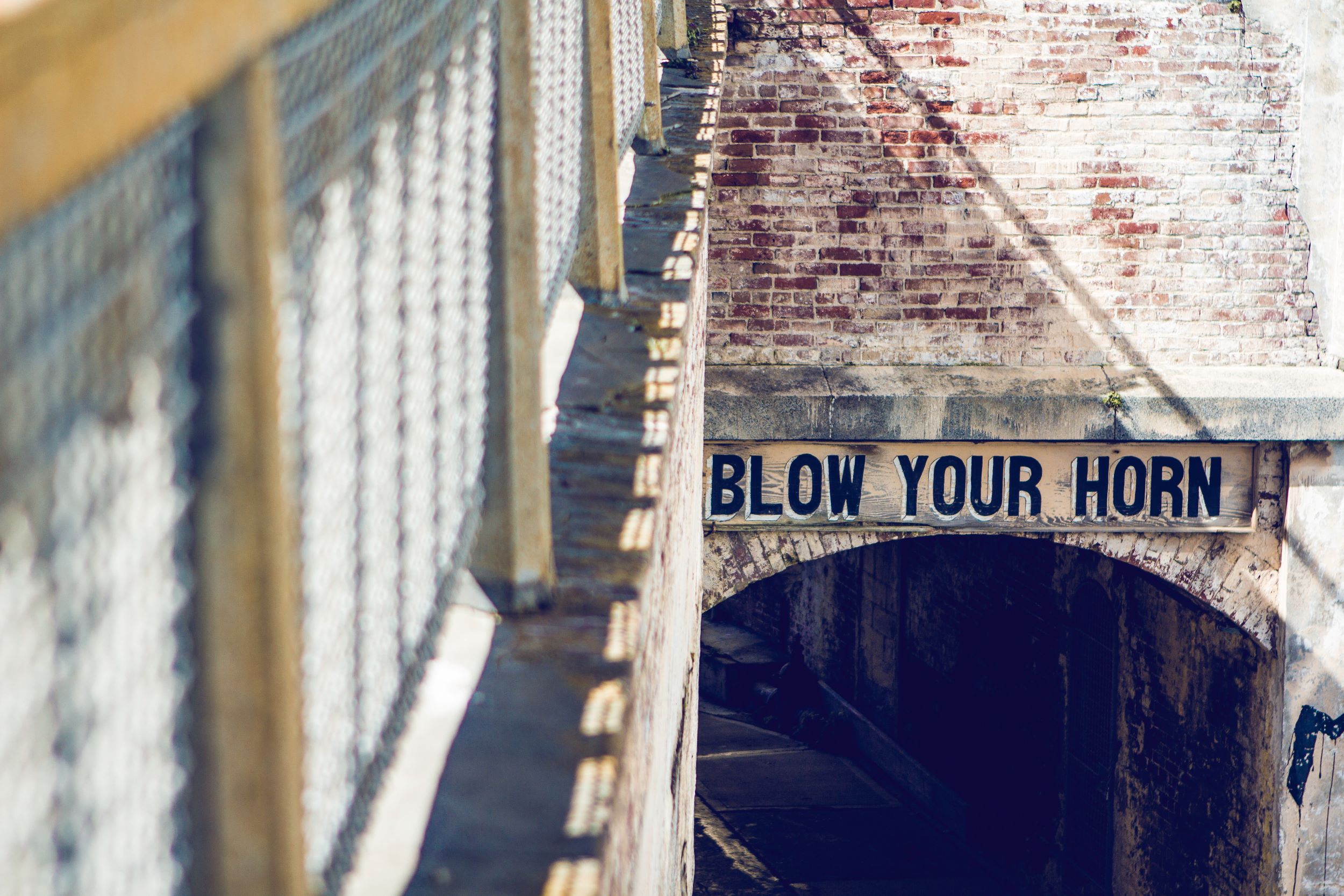 sign over tunnel that says "blow your horn"