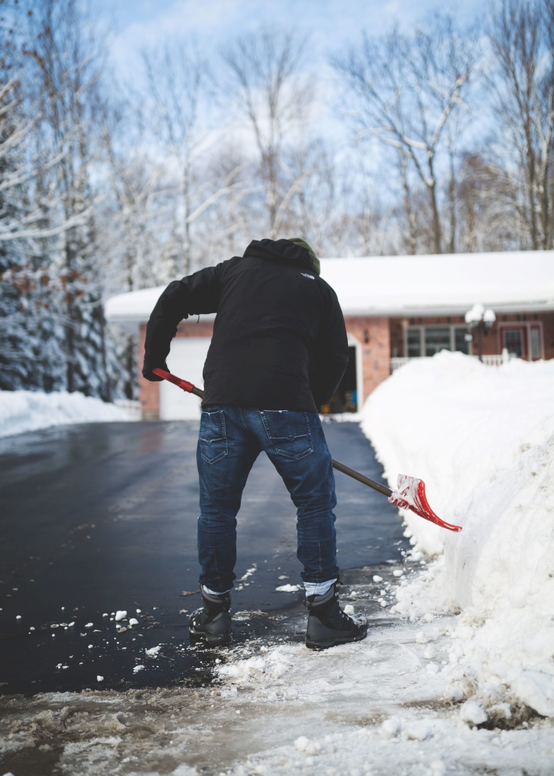 man shoveling snow off a driveway