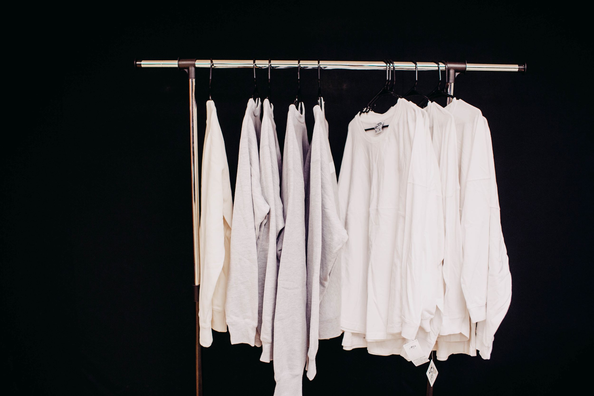 white t-shirts hanging on rack