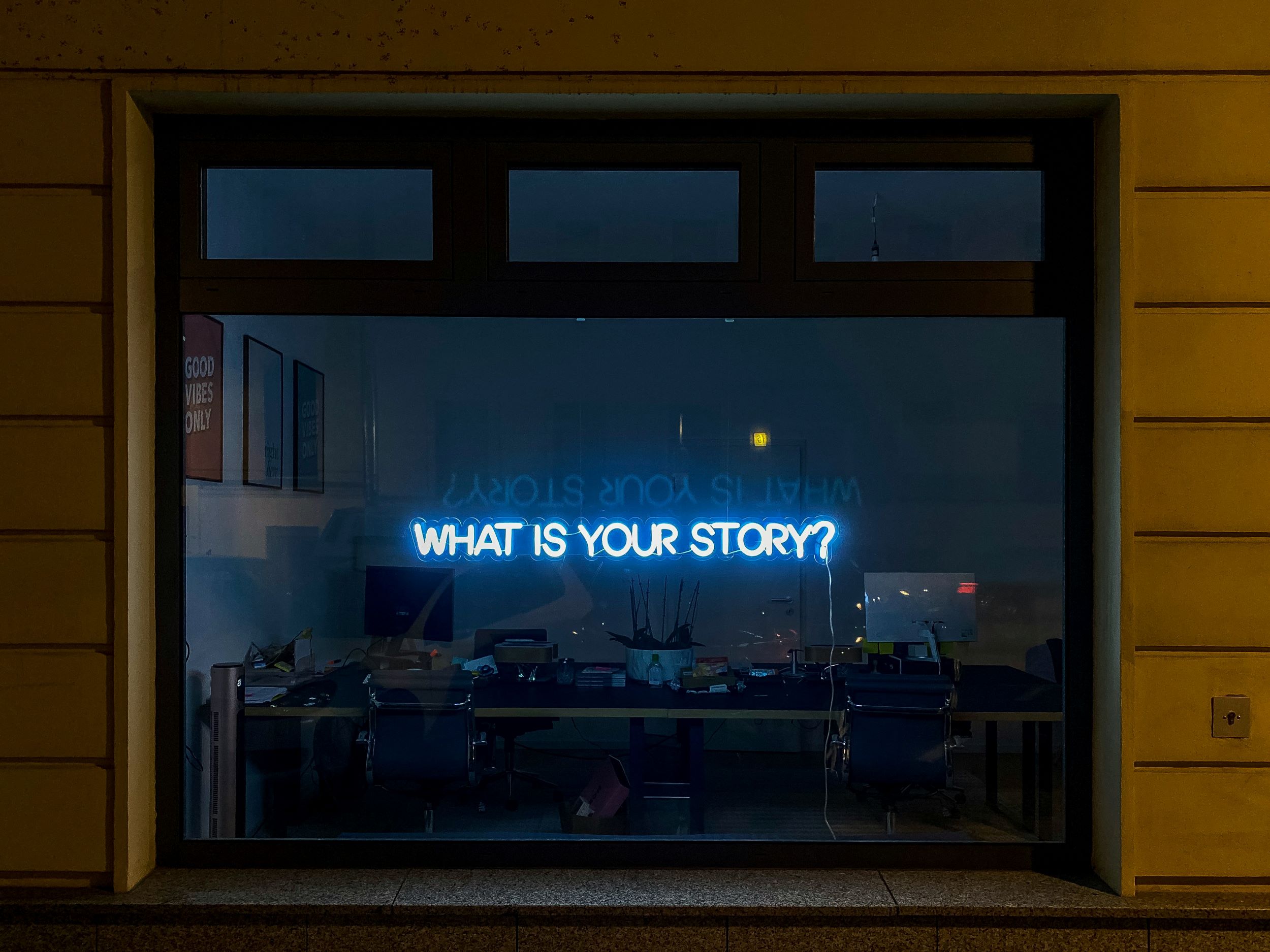 neon sign that asks "What is your story?"