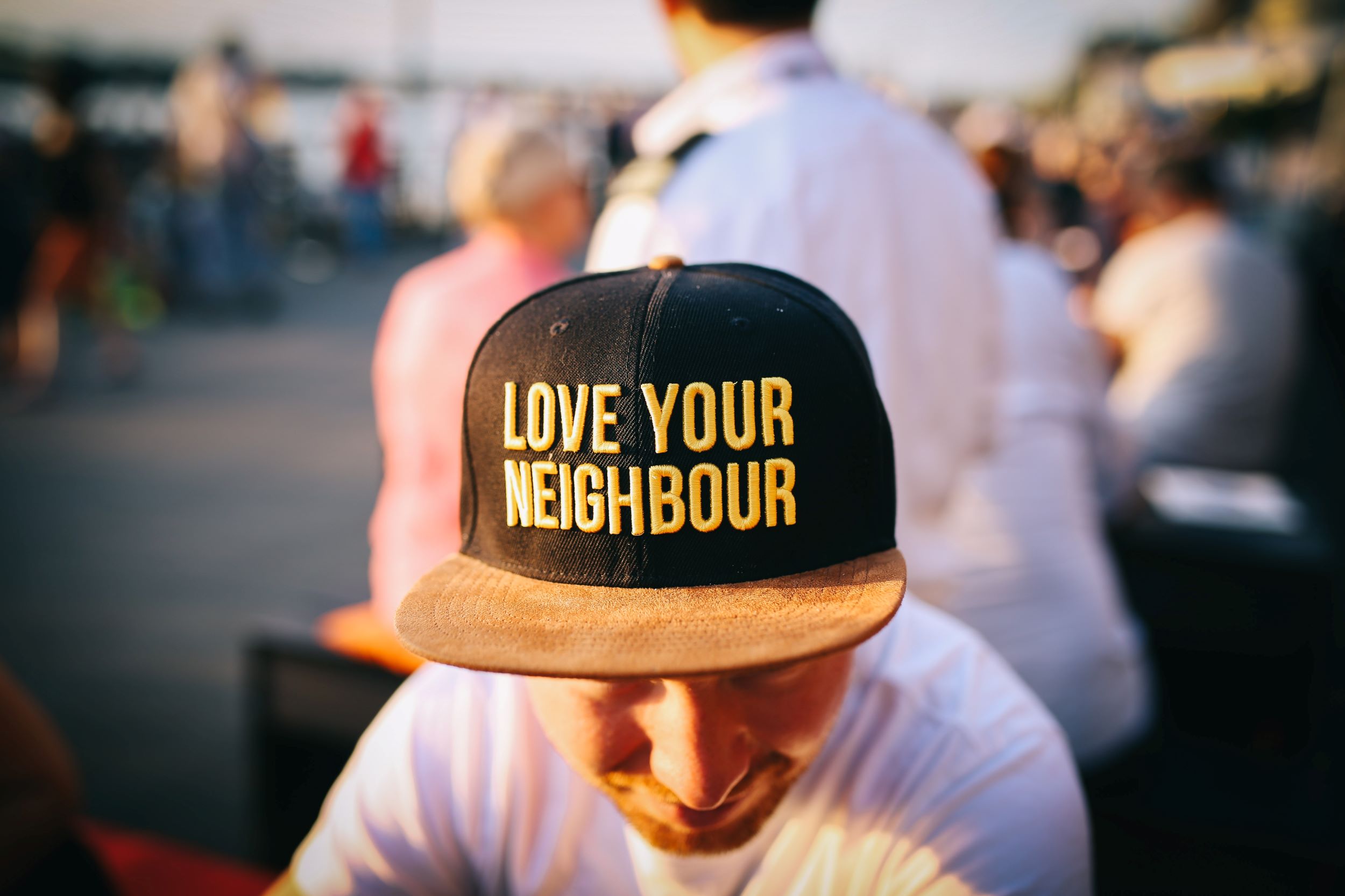 man in hat that says "love your neighbor"
