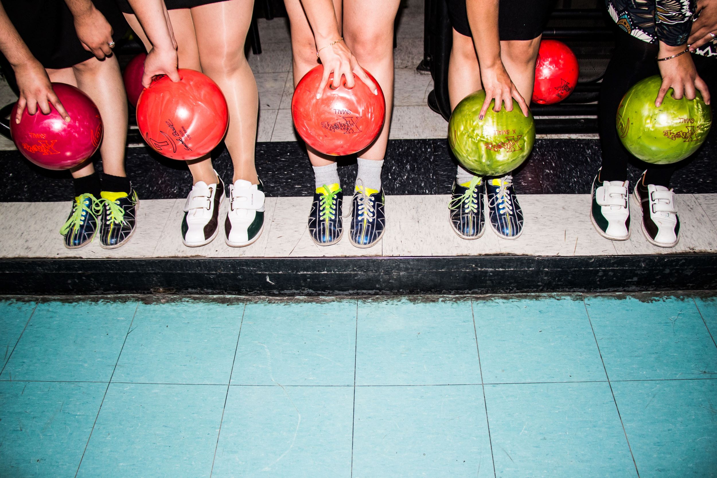 people holding bowling balls