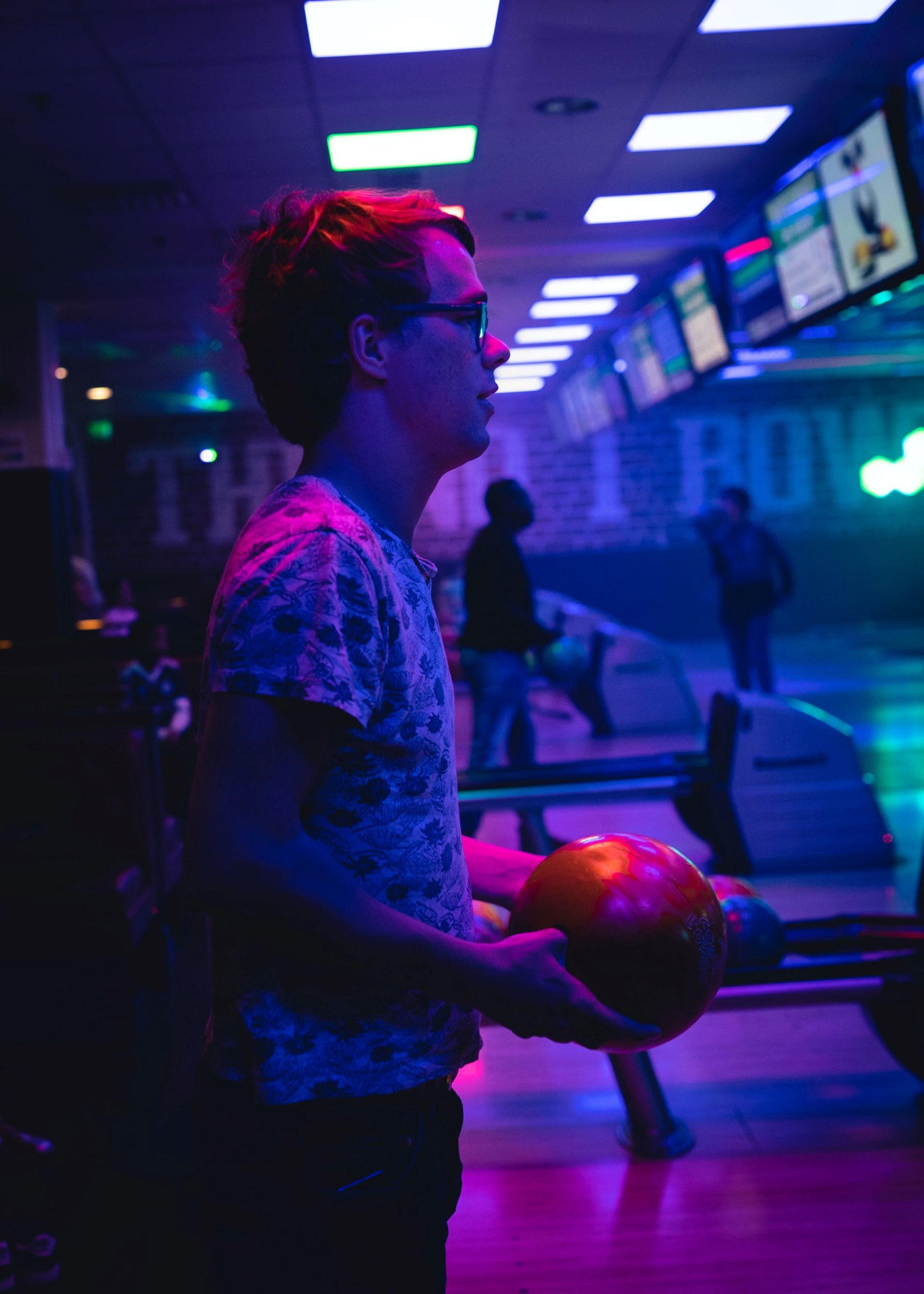 person bowling under black lights