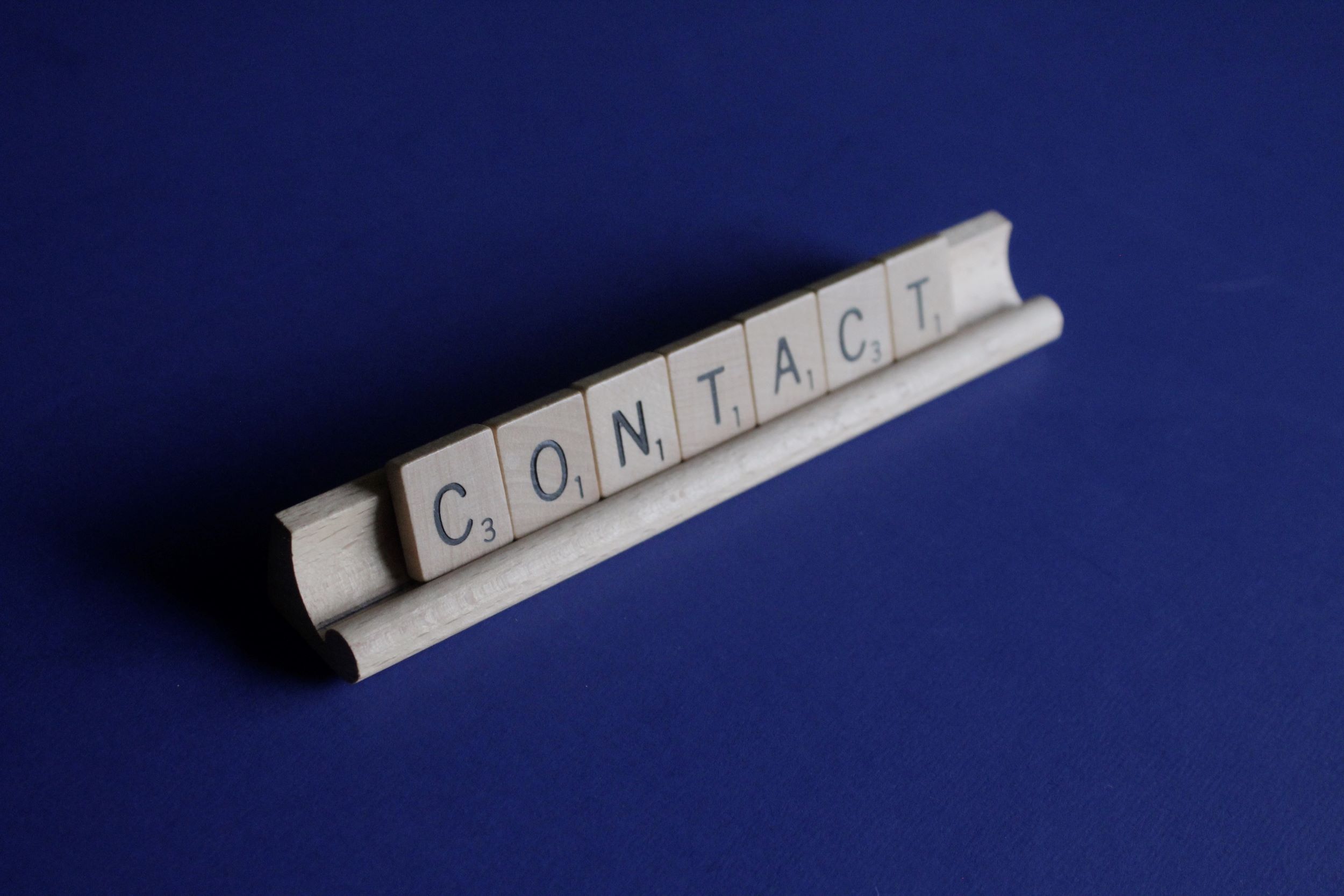 scrabble tiles that spell "contact"
