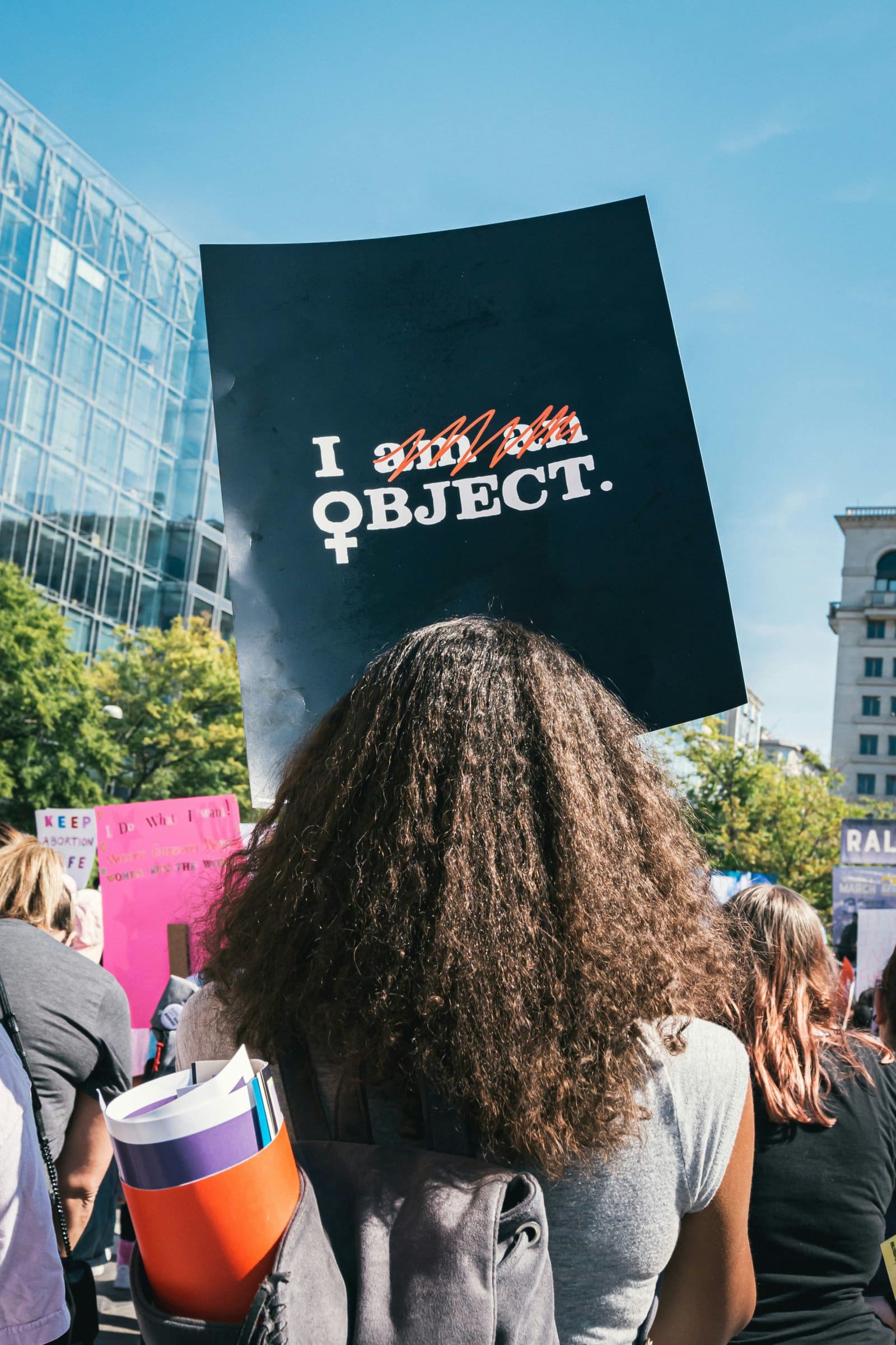 woman with protest sign that says "I object" instead of "I am an object"